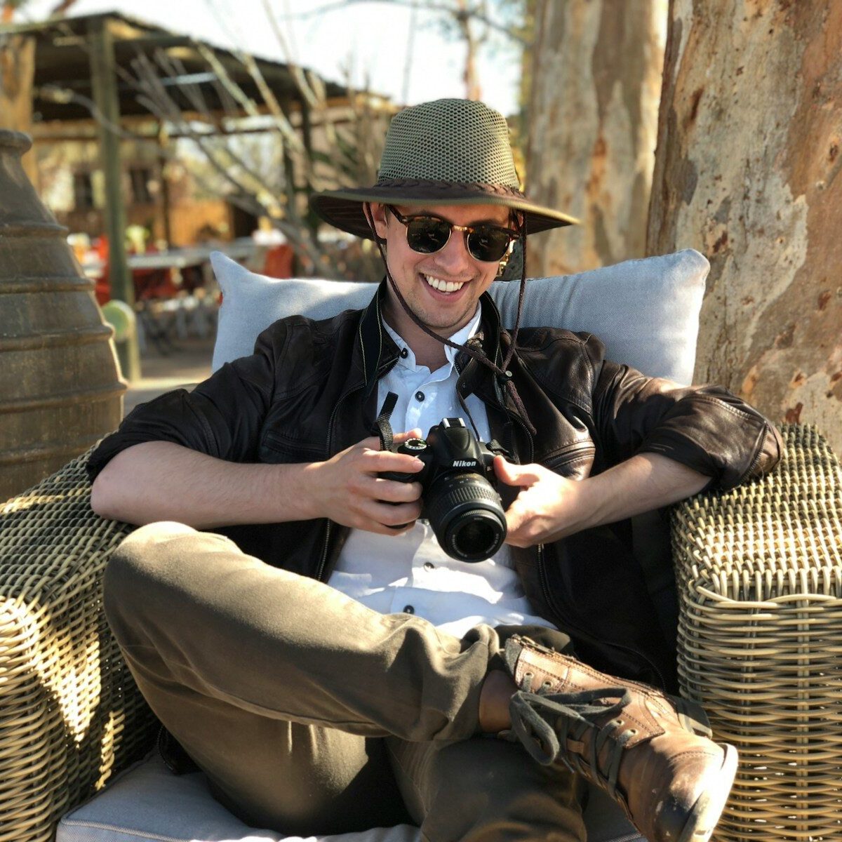 man sitting on chair while holding camera